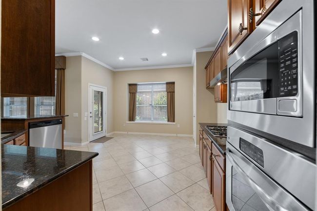 The kitchen features a built-in single oven and microwave combo, seamlessly integrated for convenience and modern culinary experiences. | Image 25