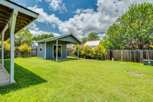 Backyard features storage shed with covered patio | Image 31