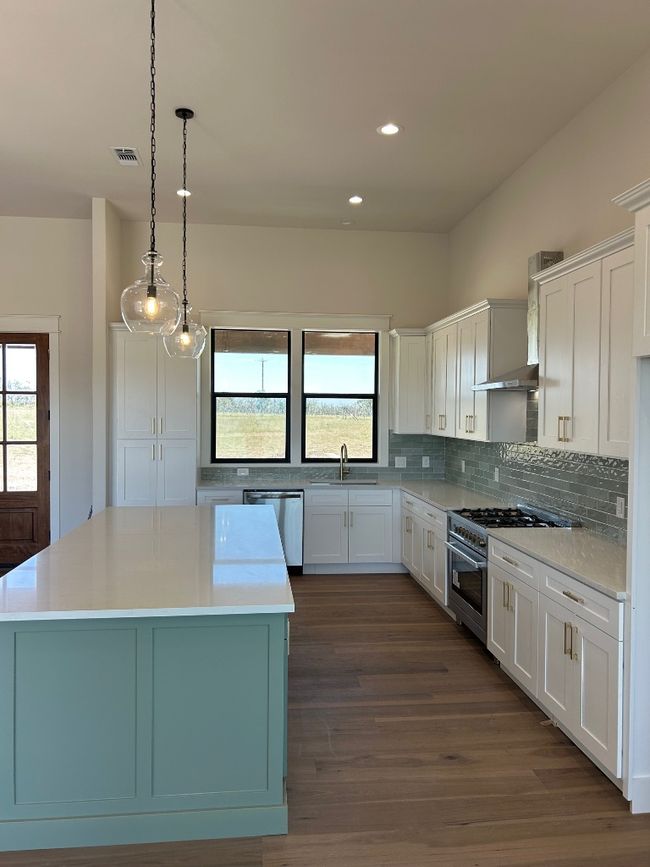 Kitchen with a sink, range, dishwashing machine, backsplash, and a kitchen island | Image 20