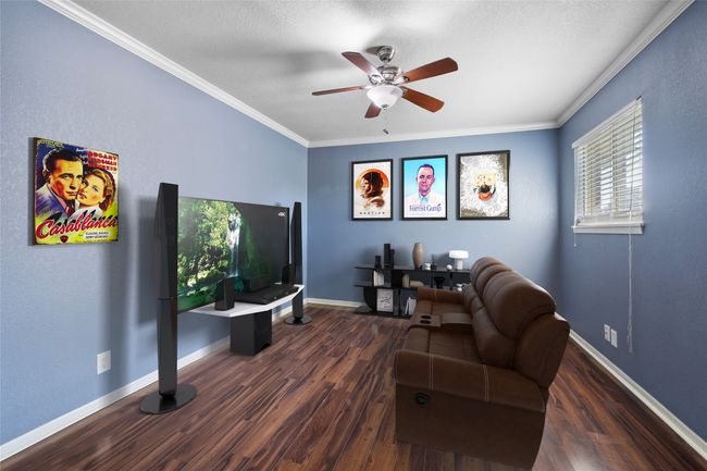 Living room with ceiling fan, wood finished floors, ornamental molding, and baseboards | Image 16