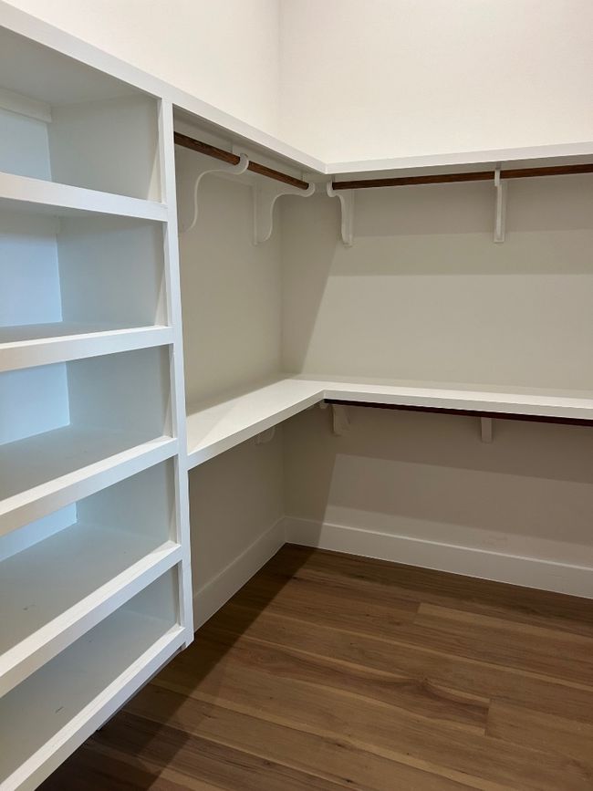 Spacious closet with dark wood-style flooring | Image 15