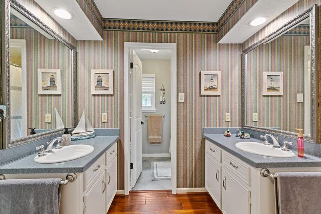 This hollywood bath features double sinks with Silestone countertops and a private bath area. | Image 24