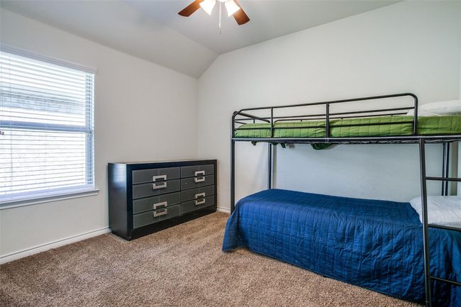 Carpeted bedroom with lofted ceiling, multiple windows, and ceiling fan | Image 19