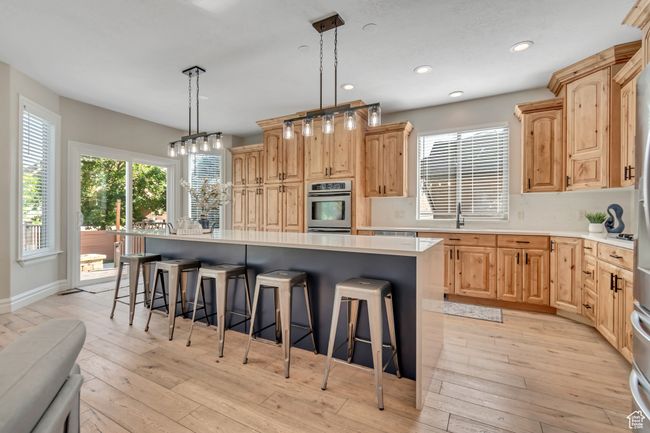 Kitchen featuring a breakfast bar area, light brown cabinets, a kitchen island, and recessed lighting | Image 8