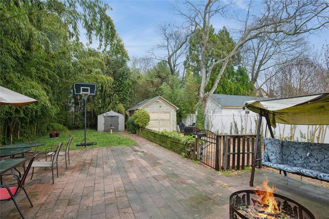 View of patio / terrace featuring outdoor dining space, an outdoor structure, a fire pit, a shed, and fence | Image 29