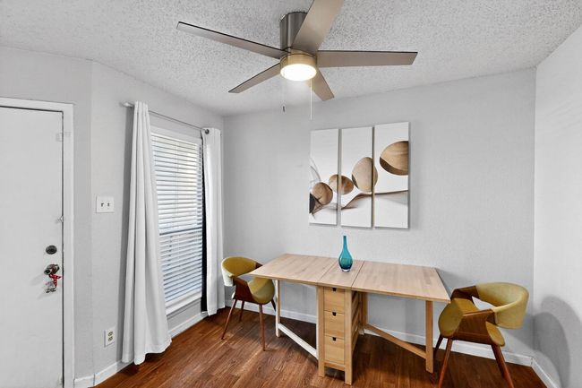 Home office featuring dark wood finished floors, a ceiling fan, and a textured ceiling | Image 7
