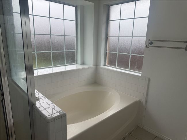 Bathroom with a bath, tile patterned floors, and baseboards | Image 13