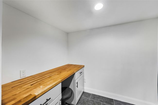 Office space featuring built in study area, dark tile patterned floors, and baseboards | Image 41