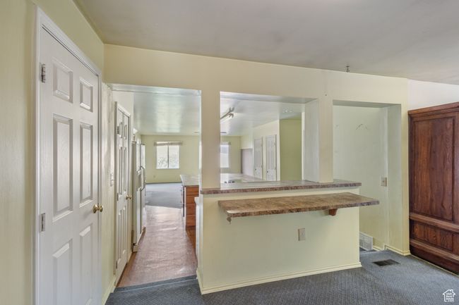 Large Kitchen featuring dark colored carpet and a breakfast bar area | Image 13