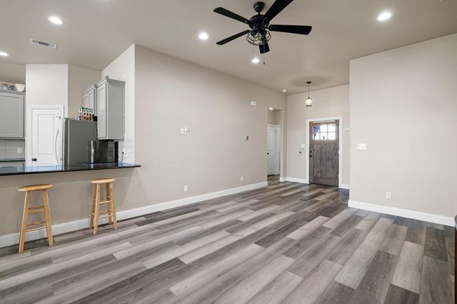 Unfurnished living room featuring visible vents, ceiling fan, baseboards, recessed lighting, and light wood finished floors | Image 7