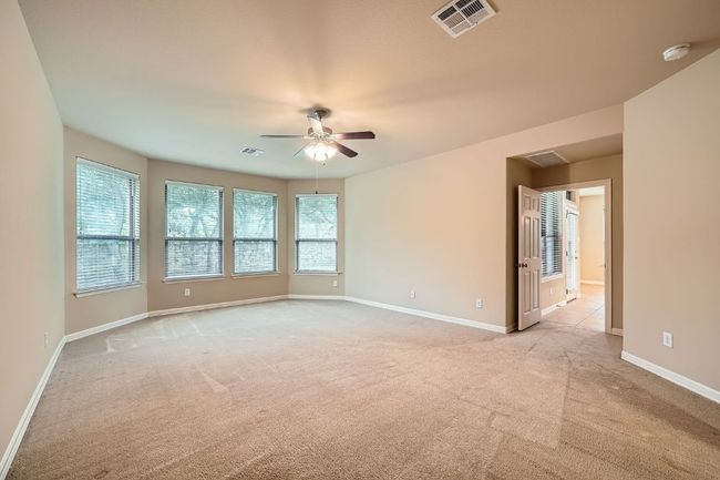 Empty room with light carpet, ceiling fan, a smoke detector, and healthy amount of natural light | Image 16