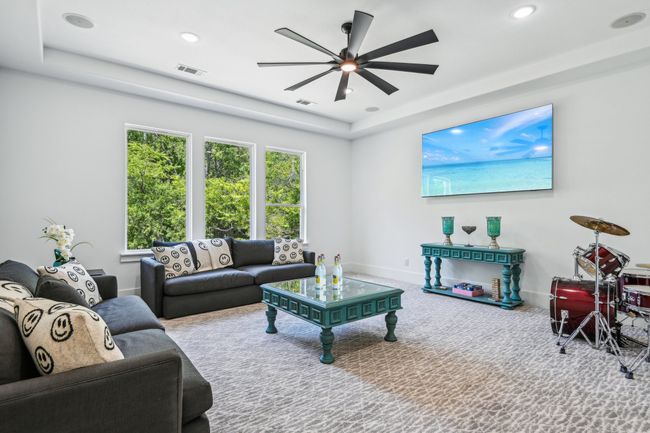 Carpeted living room featuring a ceiling fan, recessed lighting, and a tray ceiling | Image 34