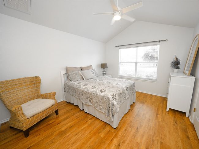 Bedroom featuring visible vents, lofted ceiling, baseboards, ceiling fan, and light wood-style flooring | Image 22