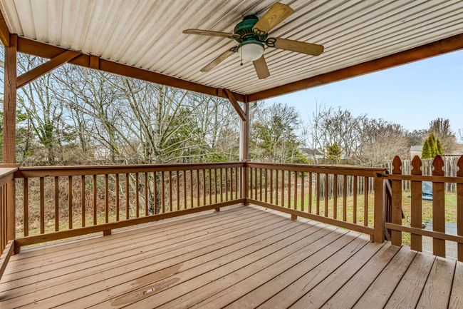 Huge covered deck with ceiling fan overlooks private back yard. | Image 30
