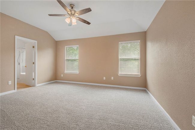 Unfurnished room featuring a textured wall, a ceiling fan, vaulted ceiling, and light colored carpet | Image 12