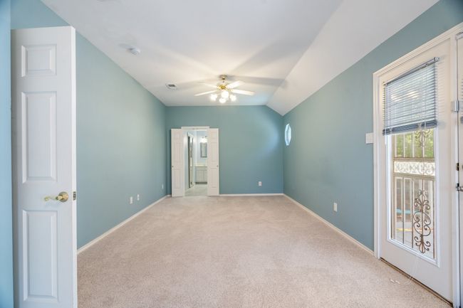 Additional living space featuring ceiling fan, visible vents, vaulted ceiling, carpet floors, and baseboards | Image 23