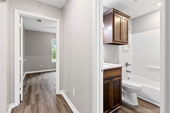 Full bath featuring wood finished floors, vanity, and shower / bath combination | Image 23