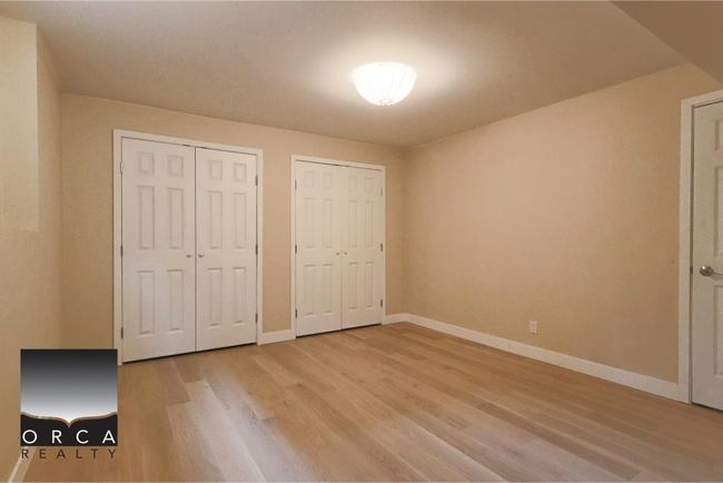 Unfurnished bedroom with multiple closets and light wood finished floors | Image 36