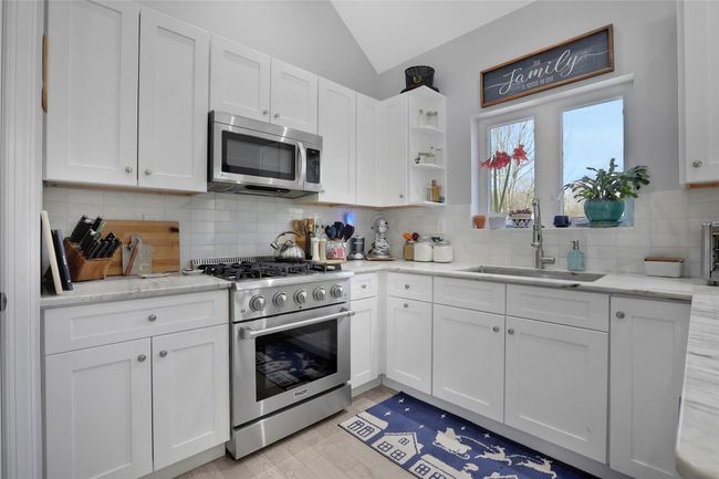 Kitchen with white cabinetry, sink, and appliances with stainless steel finishes | Image 9