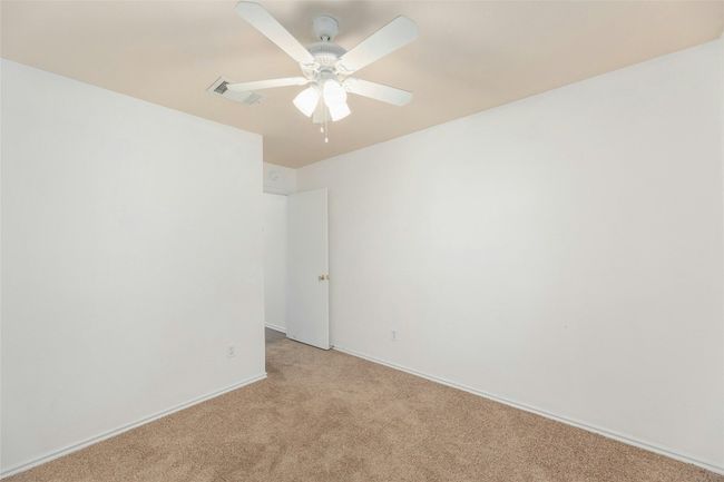 Empty room with ceiling fan, visible vents, and light colored carpet | Image 16
