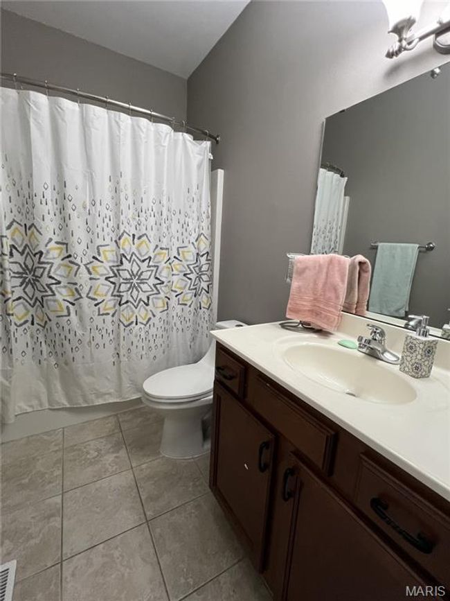 Full bath featuring vanity, tile patterned flooring, and curtained shower | Image 16