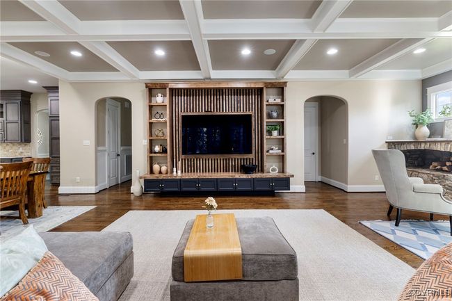 Living area featuring arched walkways, dark wood-type flooring, beam ceiling, coffered ceiling, and ornamental molding | Image 16