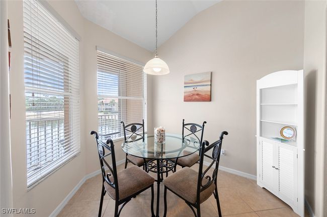 Dining area with vaulted ceiling, baseboards, and light tile patterned floors | Image 7