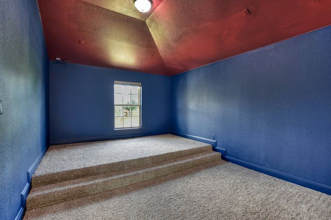 Empty room featuring a textured wall, carpet flooring, vaulted ceiling, and a textured ceiling | Image 36