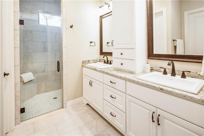 Bathroom featuring double vanity, a sink, baseboards, and a stall shower | Image 27