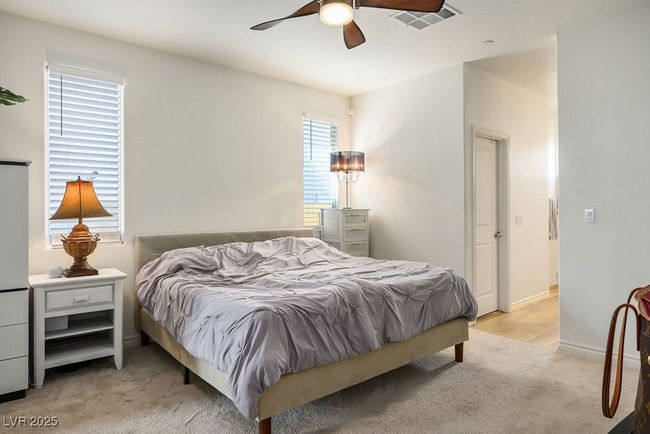 Bedroom featuring a ceiling fan, visible vents, light carpet, and baseboards | Image 20