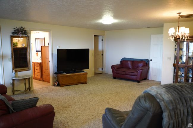 Living room with a chandelier, light carpet, and a textured ceiling | Image 19