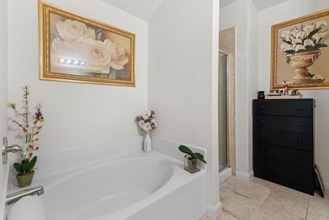 Bathroom with a bath, tile patterned floors, and a stall shower | Image 28