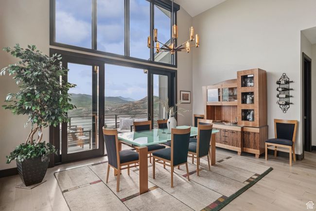 Dining space with a chandelier, high vaulted ceiling, a mountain view, and light wood finished floors | Image 24
