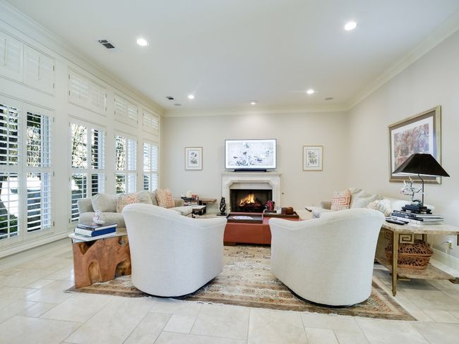Living area with ornamental molding, a lit fireplace, recessed lighting, and light tile patterned floors | Image 7