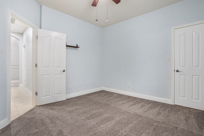 Unfurnished bedroom with carpet floors, baseboards, and a ceiling fan | Image 24