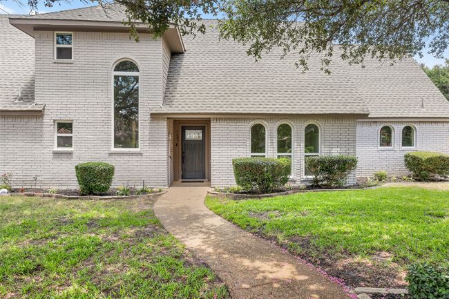 View of front facade with a shingled roof, brick siding, and a front lawn | Image 4
