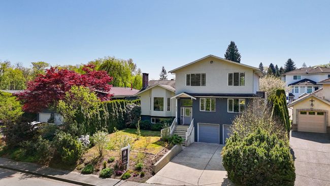 View of front of house with an attached garage, concrete driveway, a chimney, and stucco siding | Image 35