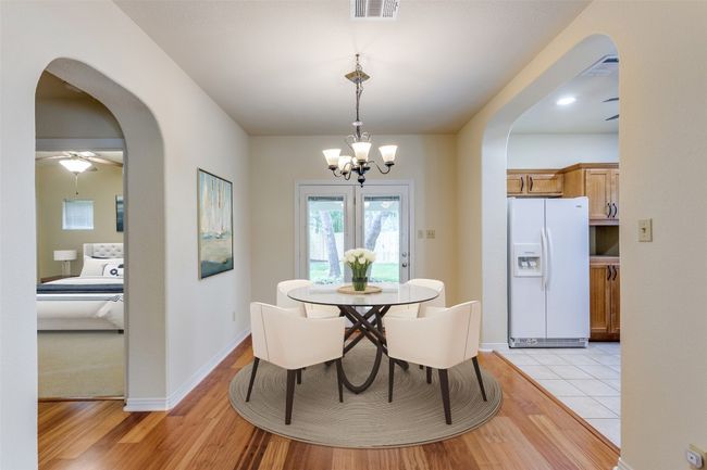 Dining area featuring arched walkways, a chandelier, light wood-style floors, and ceiling fan | Image 38