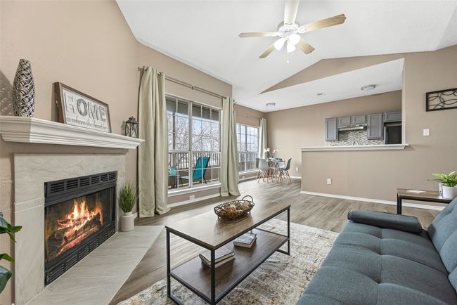 Living room featuring lofted ceiling, a high end fireplace, ceiling fan, and light wood-type flooring | Image 8