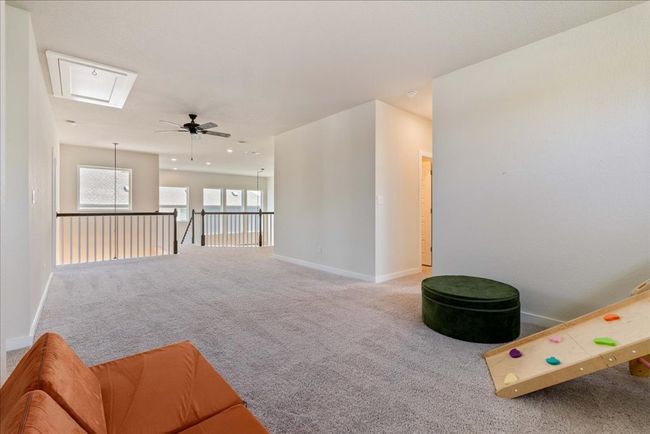 Living room featuring carpet floors, ceiling fan, attic access, and baseboards | Image 27