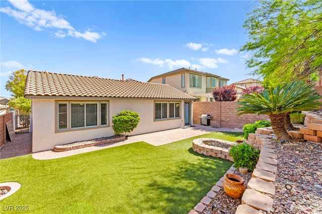 Back of house featuring stucco siding, a tiled roof, a patio area, and an outdoor fire pit | Image 44