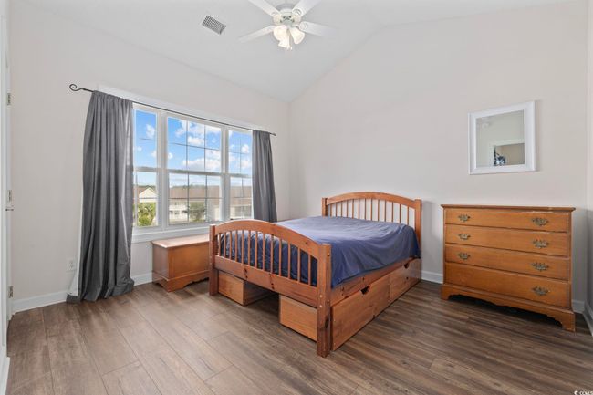 Bedroom featuring dark wood-style flooring, vaulted ceiling, ceiling fan, and baseboards | Image 17