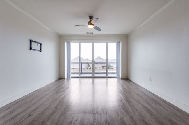 Spare room featuring a ceiling fan, wood finished floors, and crown molding | Image 15