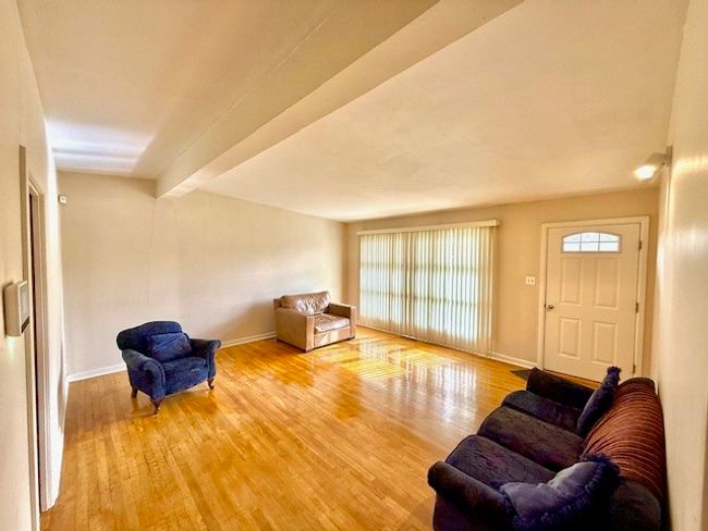 Living area with lofted ceiling with beams, baseboards, and wood finished floors | Image 7