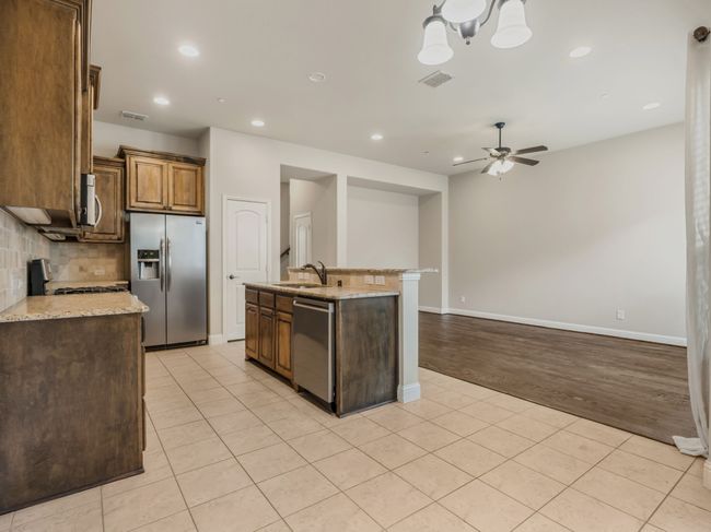 Kitchen featuring tasteful backsplash, stainless steel appliances, light tile patterned floors, ceiling fan, and recessed lighting | Image 16