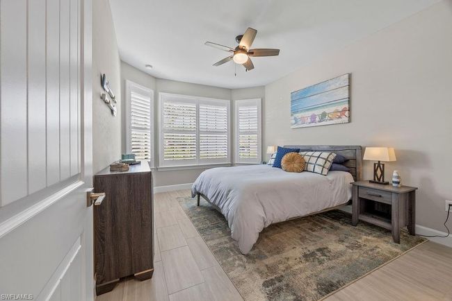 Bedroom with baseboards, ceiling fan, and wood tiled floor | Image 8