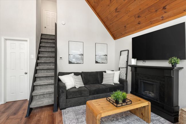 Living area featuring high vaulted ceiling, wood finished floors, stairs, wood ceiling, and a fireplace | Image 20