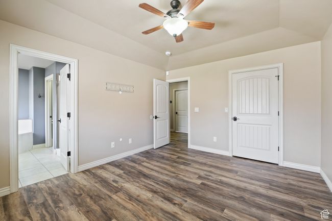 Unfurnished bedroom with wood finished floors, ensuite bathroom, and baseboards | Image 11