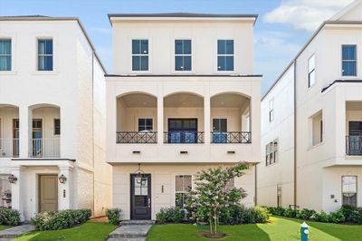 Inside the Guard Gated Houston Community inside the Loop is a 3 story Pelican Builder Built home with an Elevator shaft and outdoor living with green grass in the front of the home. | Image 1