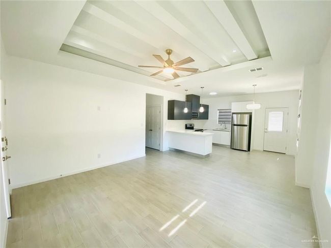 Unfurnished living room with light wood finished floors and a ceiling fan | Image 5